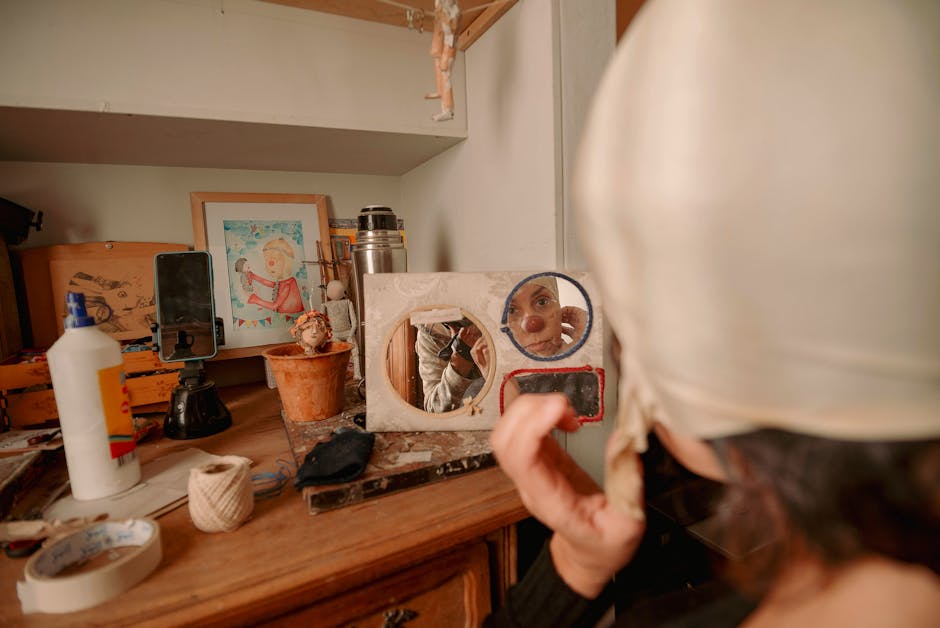 Artist wearing white cap applies makeup in cluttered workshop, reflecting creativity.